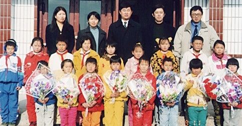 寒风中孩子们摇动手中花束欢迎我们 寒风中孩子们摇动手中花束欢迎我们